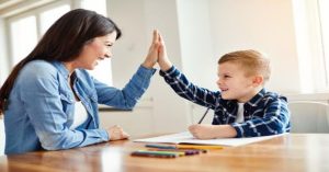 Esperto potenziante e bambino si danno il cinque sorridendo, simbolo di alleanza educativa e percorso potenziante